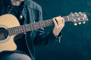 Man plays on guitar